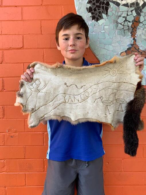 CREATIVE: Yanco Public School student Tate Tabain with the possum skin artwork he created in the lead up to NAIDOC Week. 
