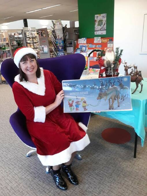 CHEER: Darlington Point author Caroline Tuohey read her Christmas-theme stories to children at storytime in Leeton recently, even dressing the part. Photo: Contributed 