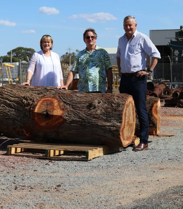 Leeton Council general manager Jackie Kruger (left) and mayor Tony Reneker (right) with Leeton Shire Ratepayers and Residents' Association president Stephen Tynan with one of the salvaged logs. Picture supplied 
