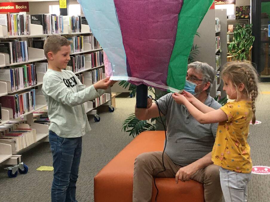 GREAT TIME: James and Valentina enjoy the balloon making session at the library with Stephen Hill. Photos: Fiona Stevens