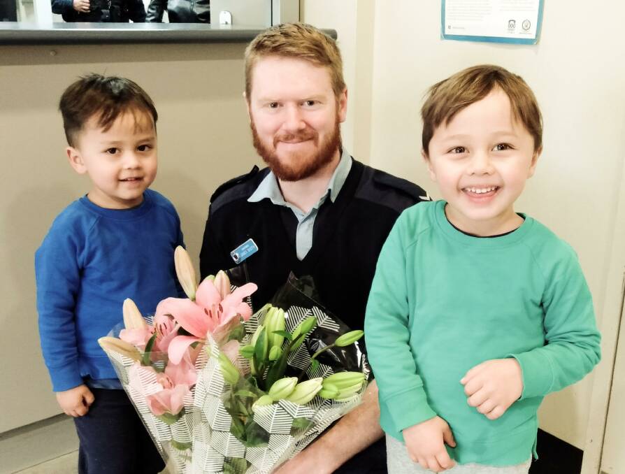 THANK YOU FLOWERS: Harrison and Oscar Floyd with James Booth from Griffith Police Station. PHOTO: Contributed