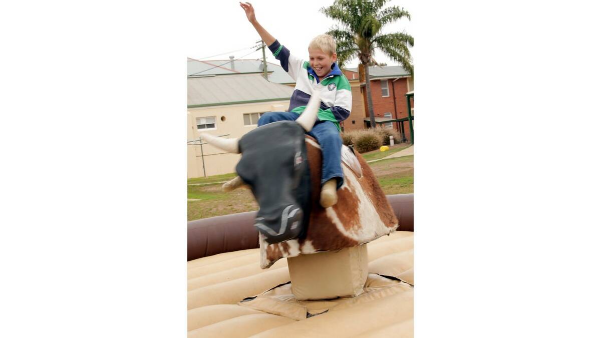 MAX Hatly, 13, rides on the mechanical bull at the Yanco Agricultural High School gala day.