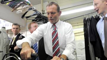 Then Liberal leader Tony Abbott tries his hand at ironing a shirt during a visit to a dry cleaner's in Queanbeyan in 2010. Picture: AAP