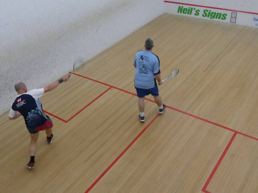 ON FIRE: Tim Allen fires a shot down the wall with Sean Ryan watching on. Leeton Squash resumed last week.