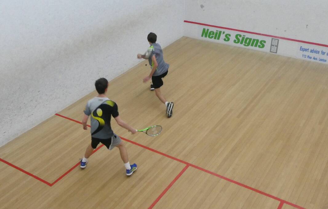 Will Rawle about to smash a backhand, with Declan Ryan ready to react.