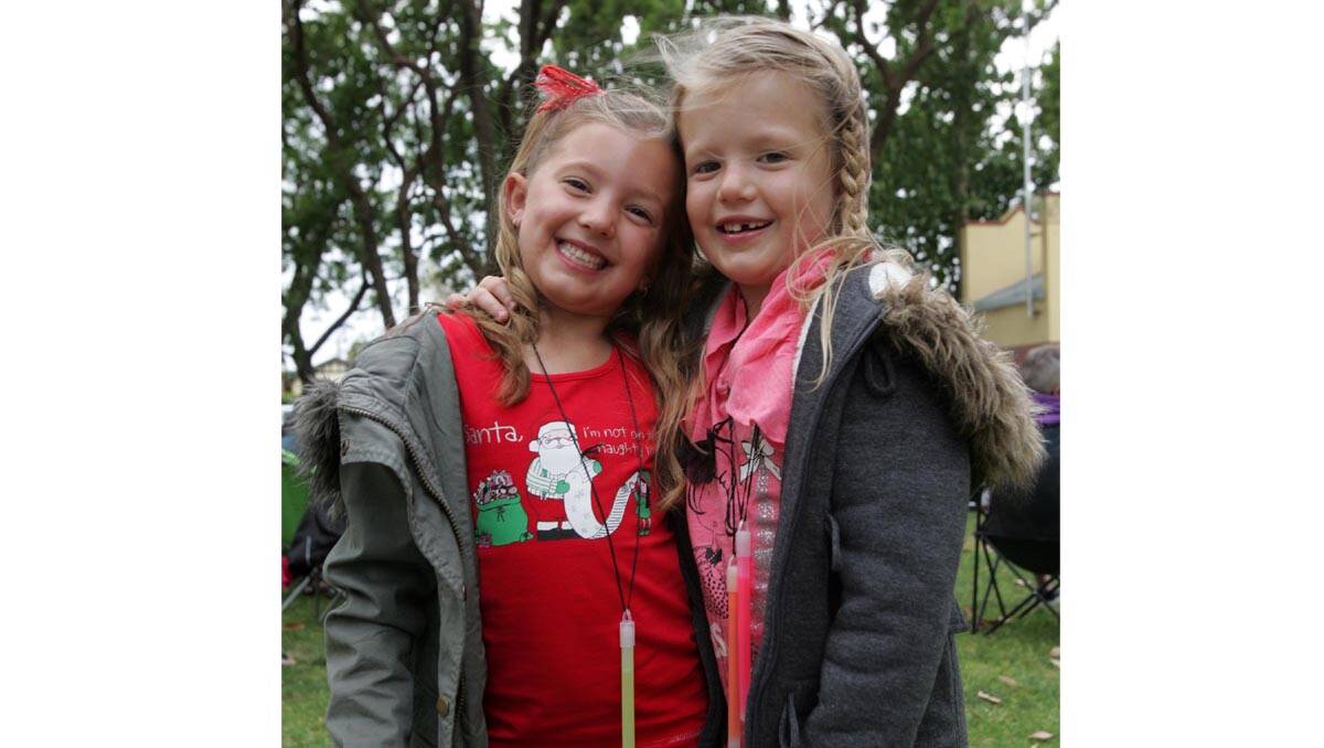 Neive Davies, 6, (left) and Libby Orlick, 6, are all smiles at Carols in the Park on Sunday.