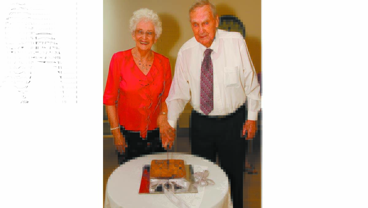 YVONNE (left) and Norm Houghton cut the cake at their 60th wedding anniversary celebration last Saturday.