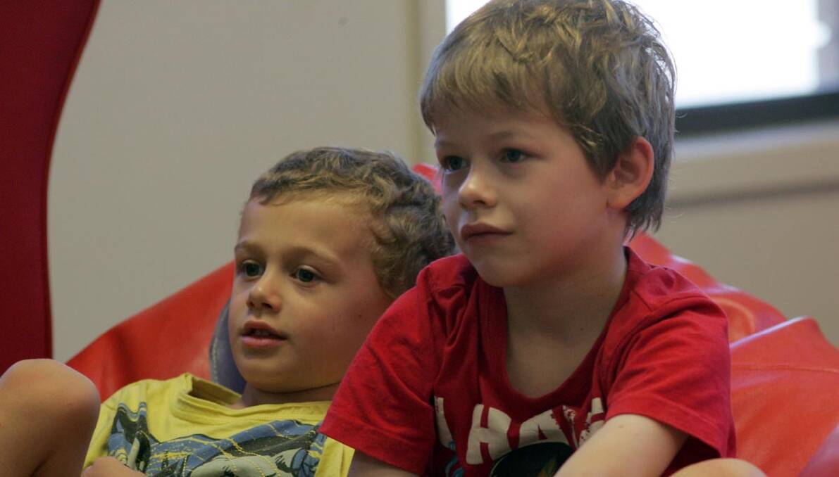 ARLO Ciaverella (left) and Remy Casey listen intently to the toilet humour-themed storytime on Wednesday morning.